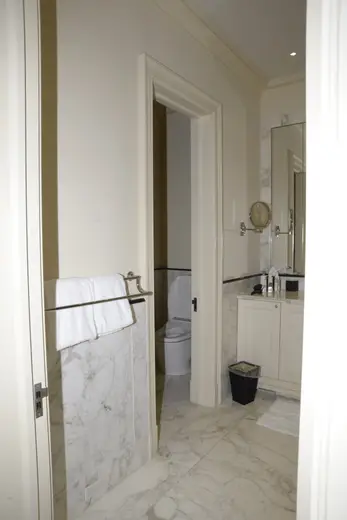 Bagno: EFTA00000239 - Bathroom with white marble flooring walls and cabinetry featuring a towel r