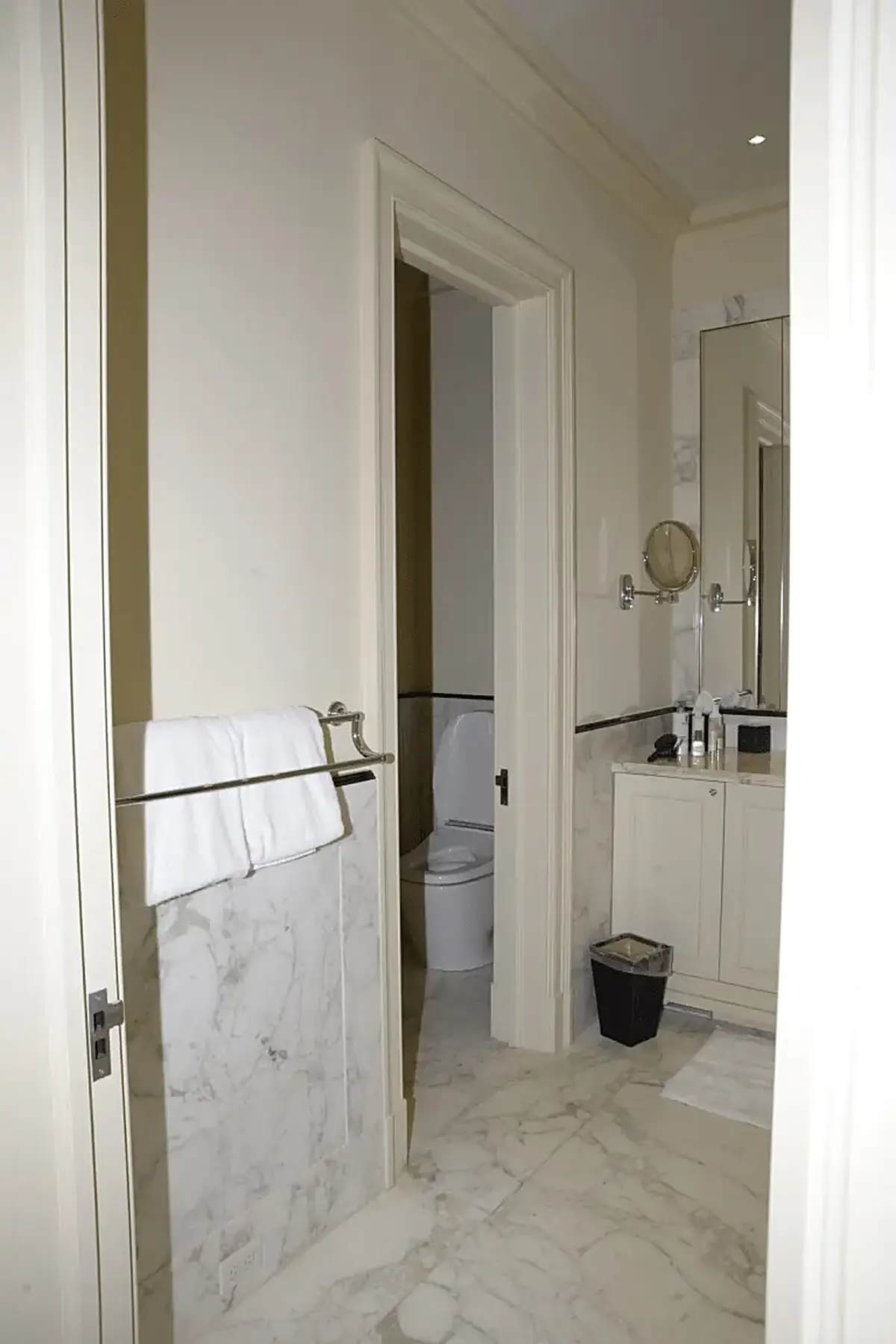 Bagno: EFTA00000239 - Bathroom with white marble flooring walls and cabinetry featuring a towel r