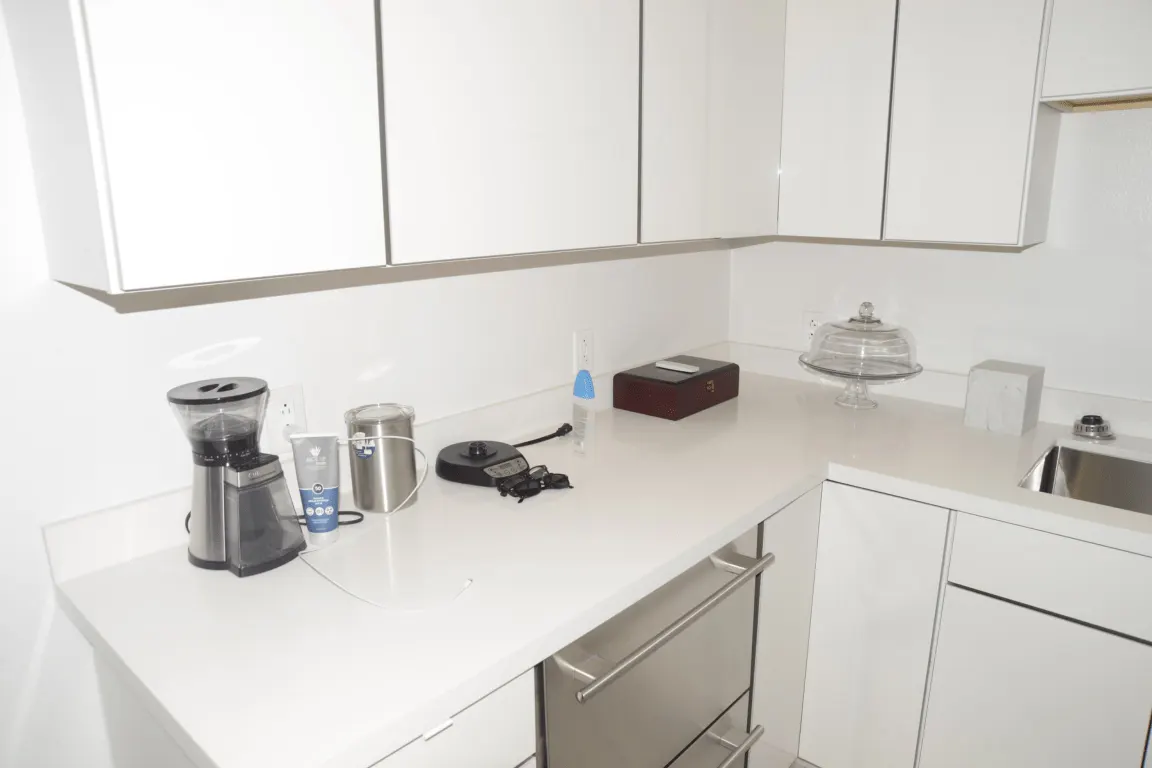 Bathroom: EFTA00002874-Pool-House - Modern white kitchen with stainless steel sink coffee maker and 
