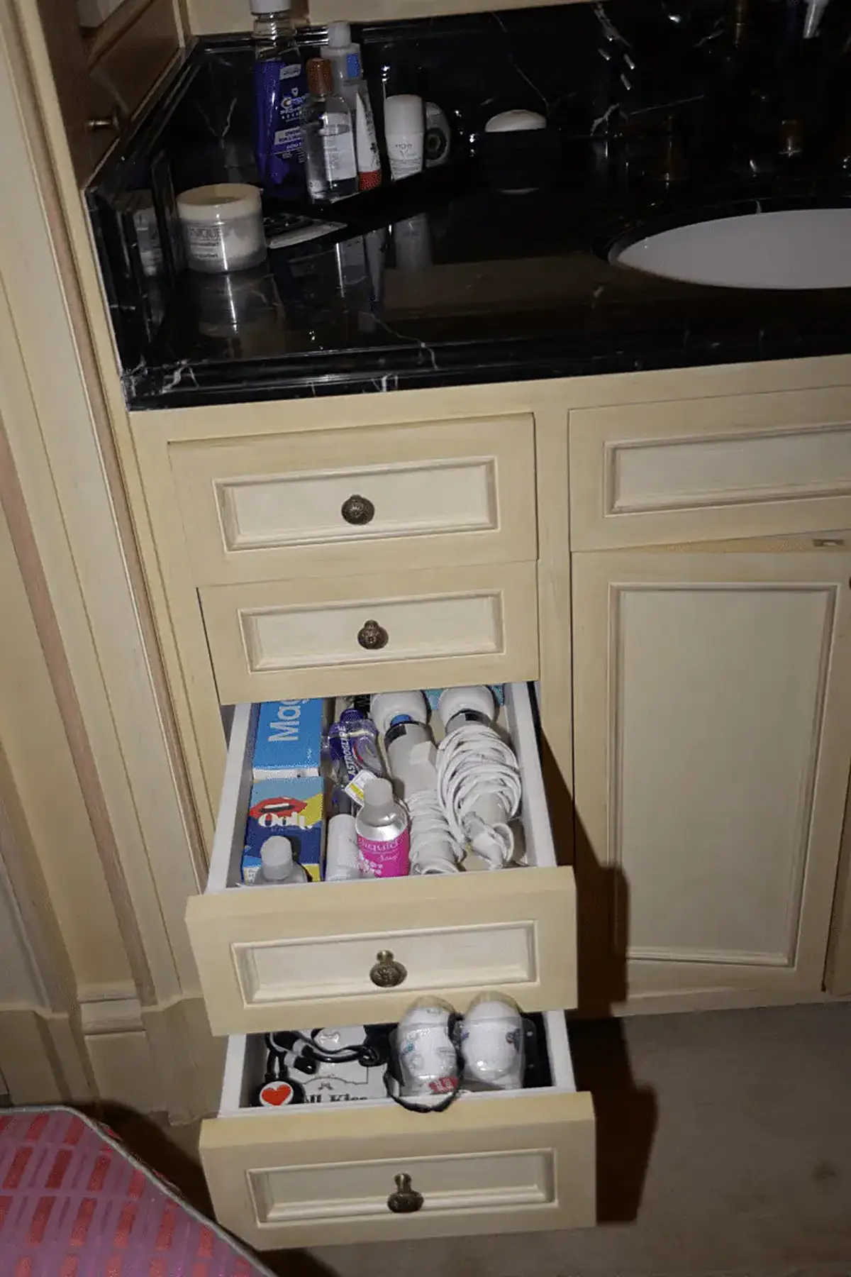 Bathroom: EFTA00000505 - Bathroom vanity with open drawers revealing toiletries toothbrushes and per