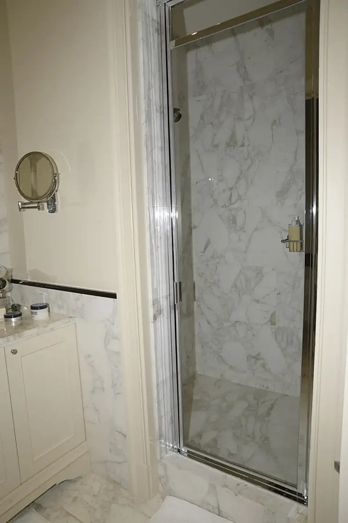 Bathroom: EFTA00000605 - Luxurious bathroom featuring marble walls a glass shower door and a vanity 