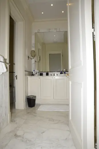 Bagno: EFTA00000606 - Spacious bathroom featuring white marble flooring a large vanity with a mir