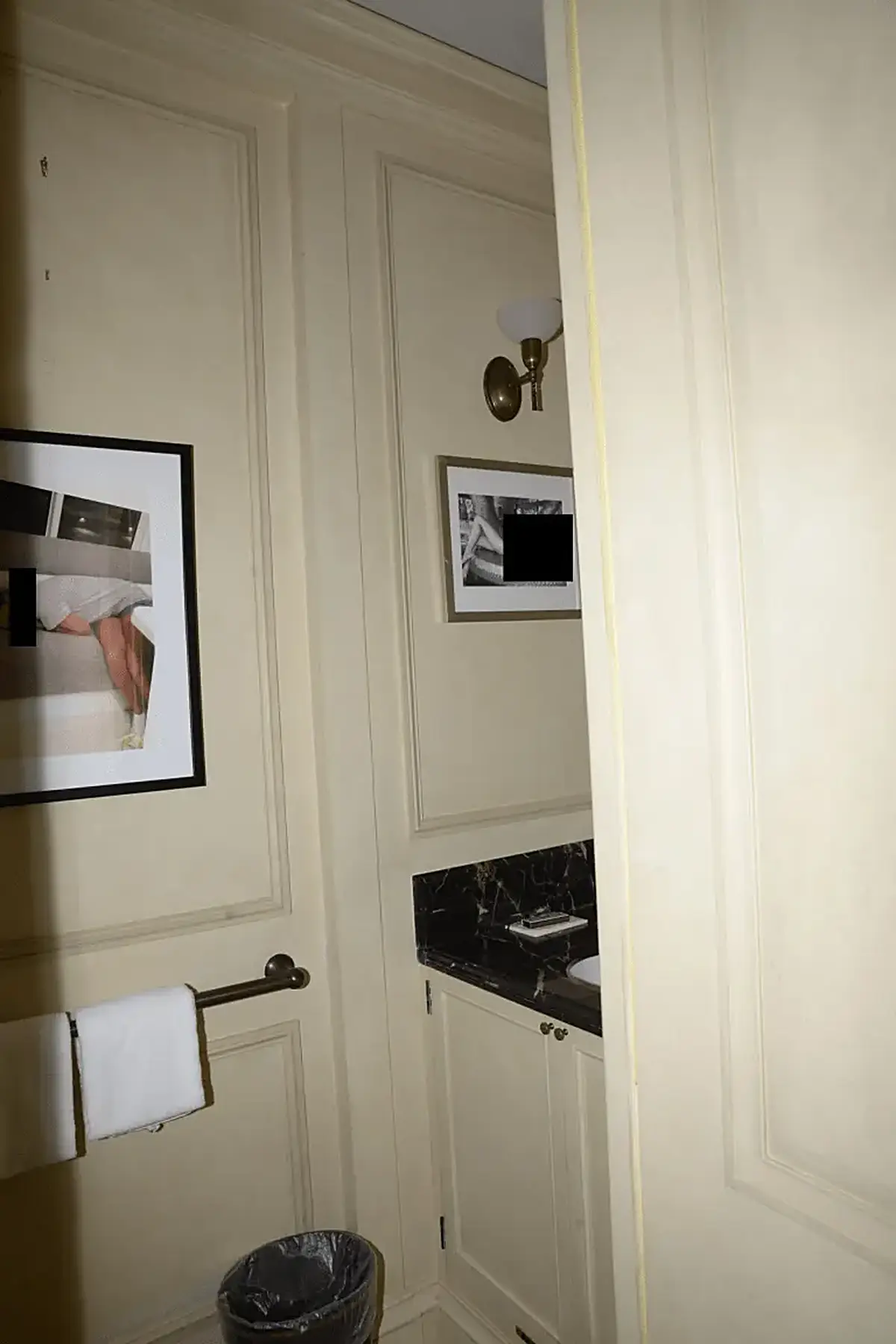 Bathroom: EFTA00000637 - Bathroom with cream walls framed artwork a black marble countertop and a to