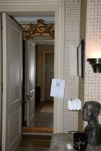 Bagno: EFTA00000904 - Luxurious bathroom doorway features ornate gold mirror patterned wallpaper 