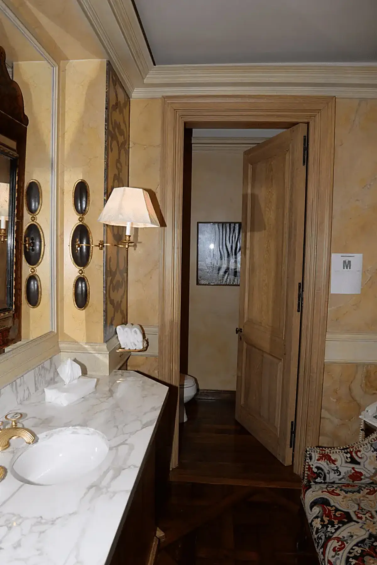 Bathroom: EFTA00001023 - Luxurious bathroom features a marble countertop elegant wall sconces and a