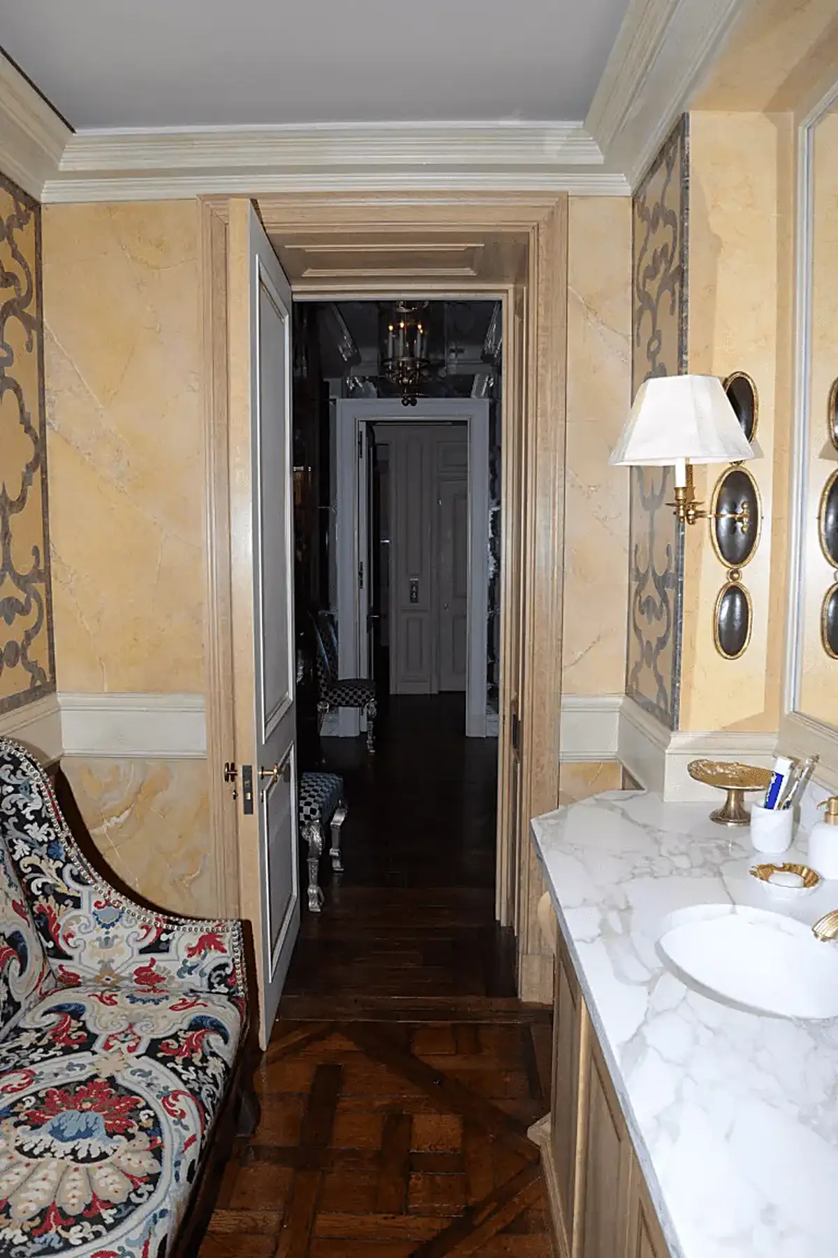 Bathroom: EFTA00001024 - Luxurious bathroom with marble countertop ornate wall art and a patterned a