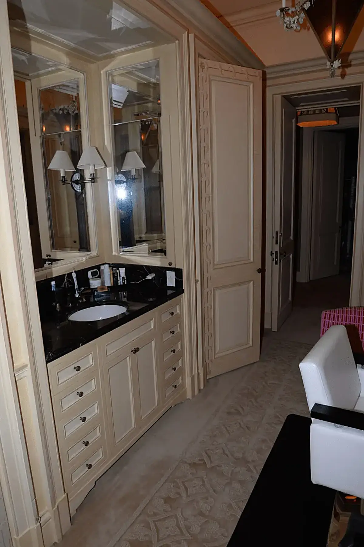 Bathroom: EFTA00001062 - Luxurious bathroom with a black marble countertop cream-colored cabinetry a