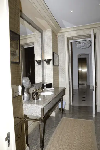 Bagno: EFTA00000805 - Elegant bathroom with marble countertop ornate mirror and patterned wallpap