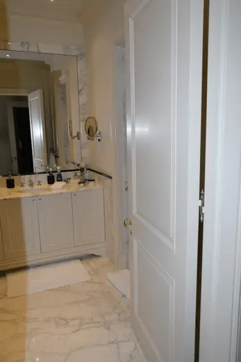 Bagno: EFTA00001117 - Spacious bathroom featuring white marble floors a large vanity with a sink 