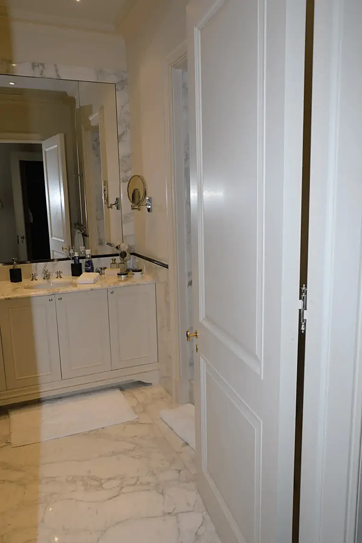Bathroom: EFTA00001117 - Spacious bathroom featuring white marble floors a large vanity with a sink