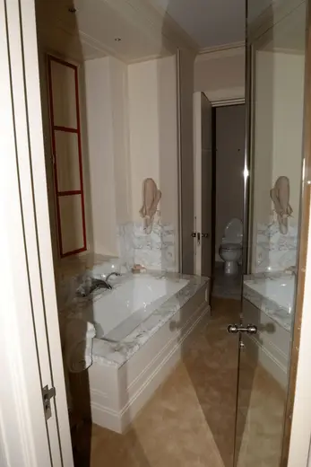 Bagno: EFTA00001138 - Luxurious bathroom featuring a white bathtub with marble countertops a red-