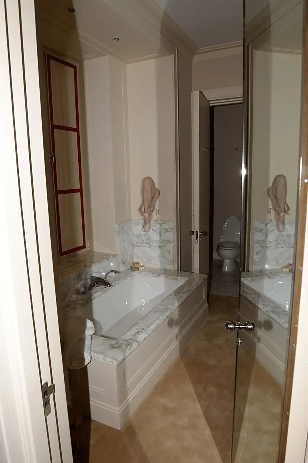 Bathroom: EFTA00001138 - Luxurious bathroom featuring a white bathtub with marble countertops a red-