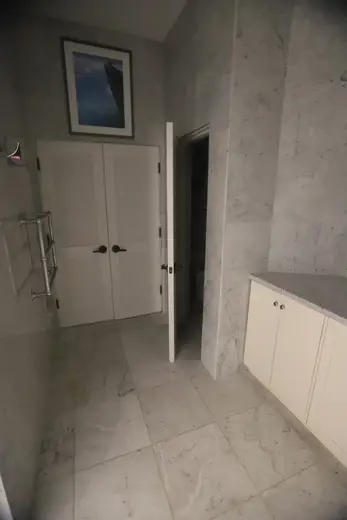 Bagno: USVI IMG 5424 - Modern bathroom with marble floors and walls white cabinets a framed pictu