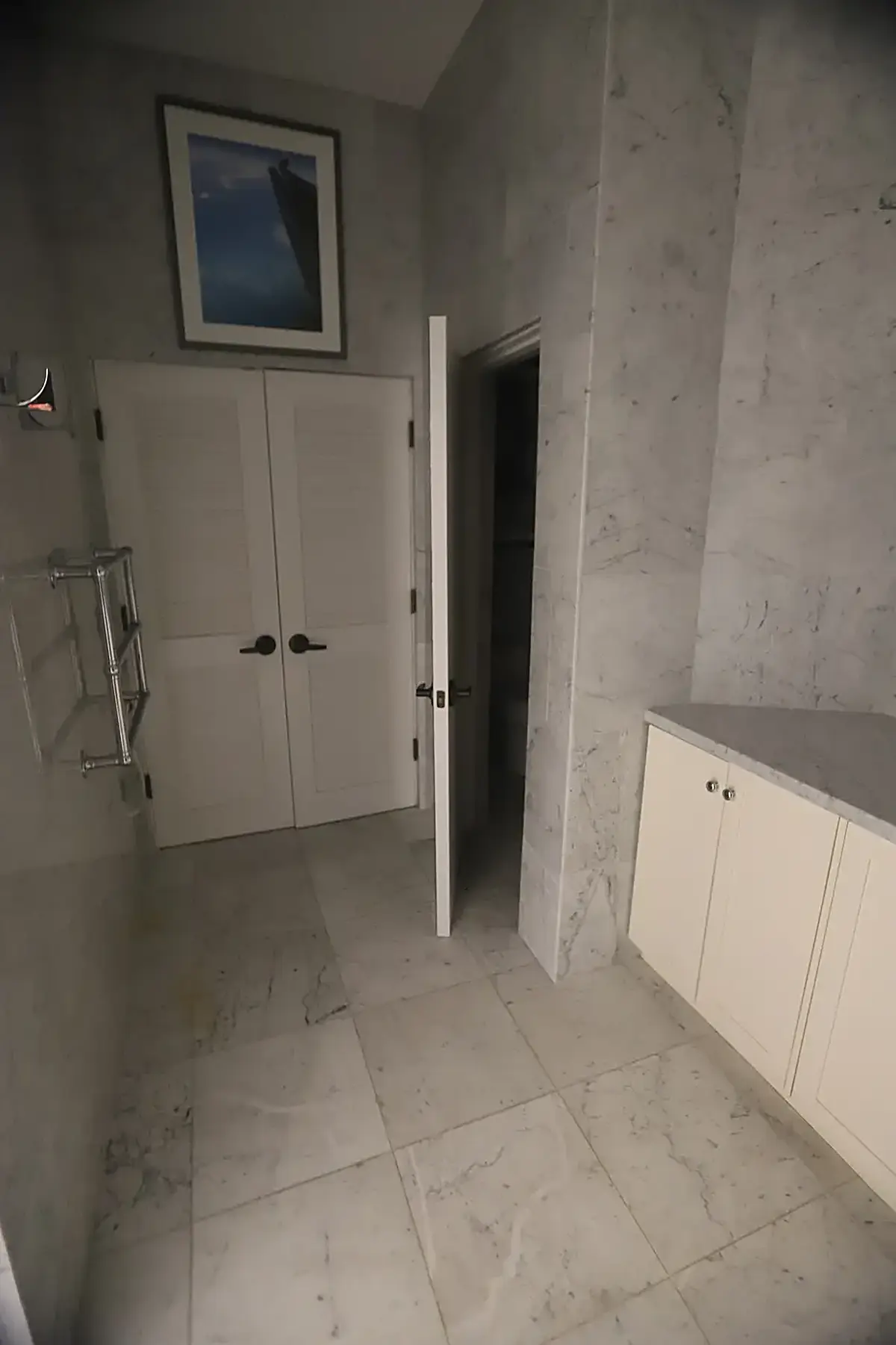 Bathroom: USVI IMG 5424 - Modern bathroom with marble floors and walls white cabinets a framed pictu
