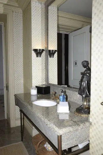 Bagno: EFTA00000791 - Elegant bathroom features a granite countertop white sink bronze faucet wal