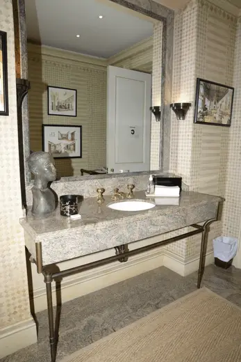 Bathroom: EFTA00000048 - Elegant bathroom vanity with marble countertop brass fixtures and patterned
