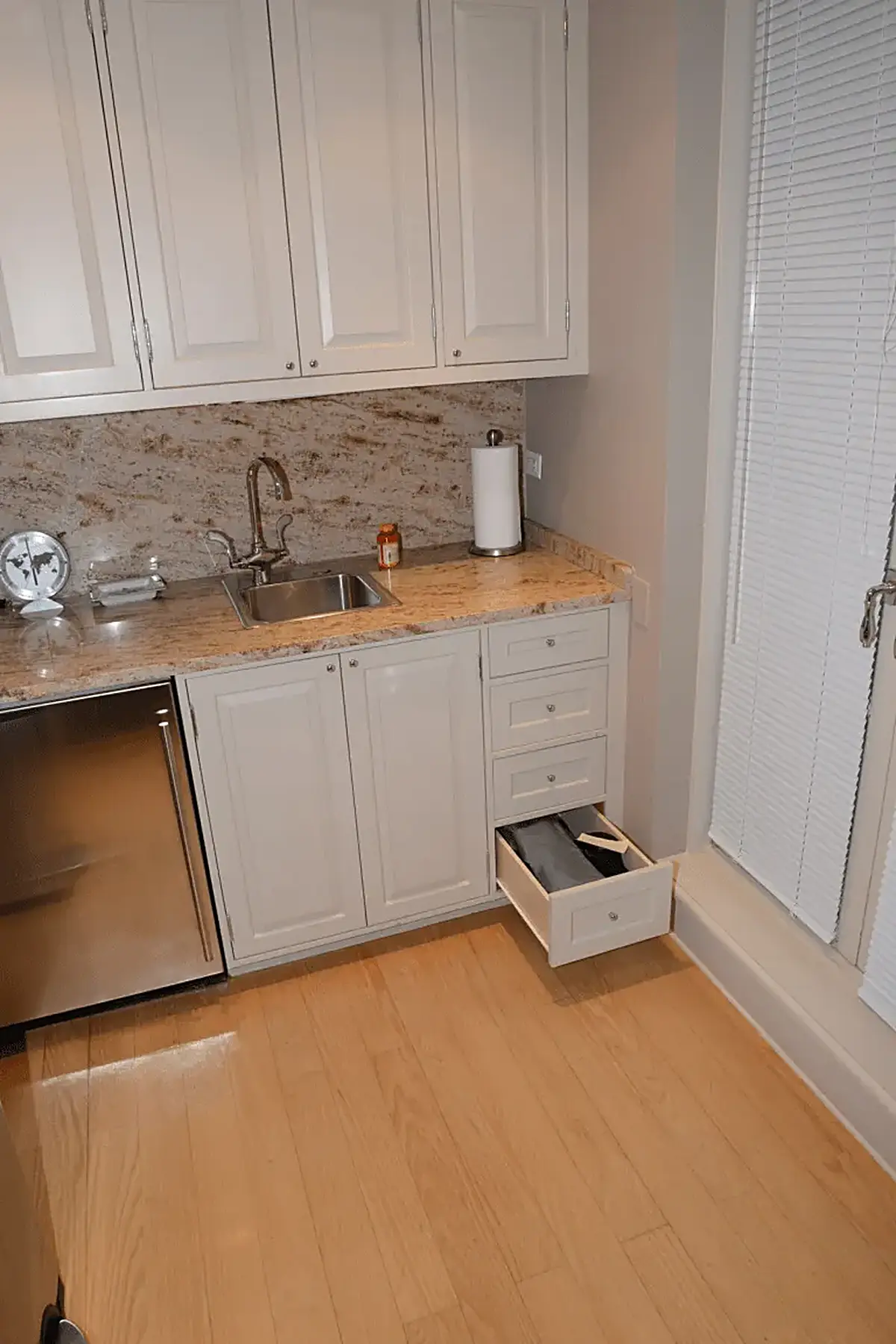 Bathroom: EFTA00001370 - Kitchen nook with white cabinets granite countertop stainless steel sink an