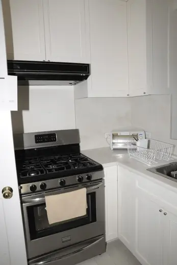 Bagno: EFTA00000566 - Modern kitchen with white cabinets a stainless steel gas range and a counte