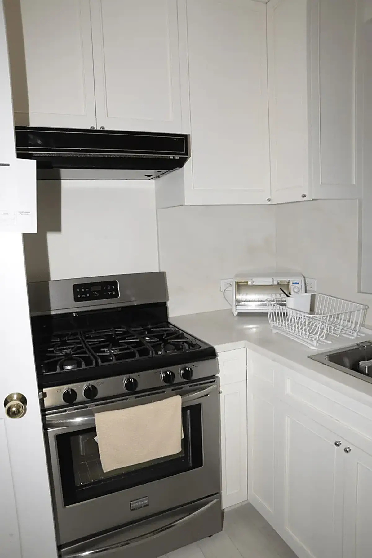 Bathroom: EFTA00000566 - Modern kitchen with white cabinets a stainless steel gas range and a counte