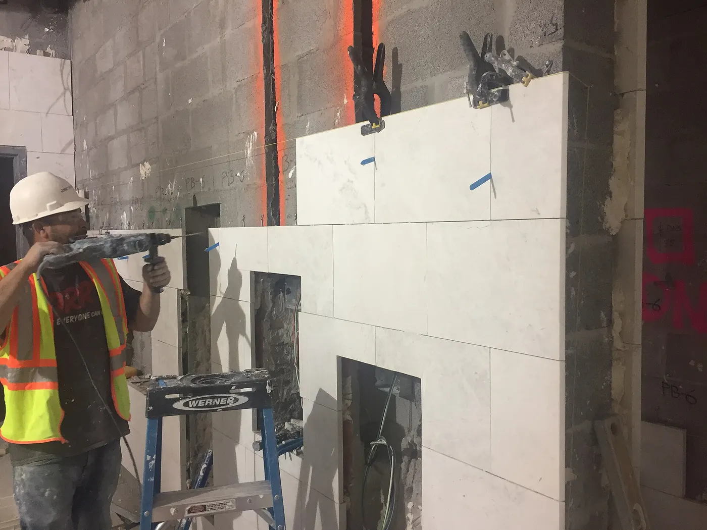 Bagno: Continued installation of marble finishes along the west wall of the women’s bathroom in t