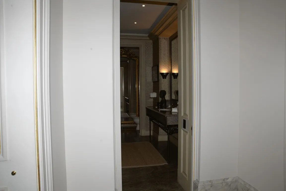Bathroom: EFTA00000043 - View through an open doorway into a luxurious bathroom featuring marble flo