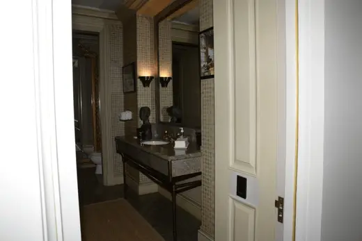 Bagno: EFTA00000046 - Luxurious bathroom with a marble countertop ornate gold-framed mirror and p