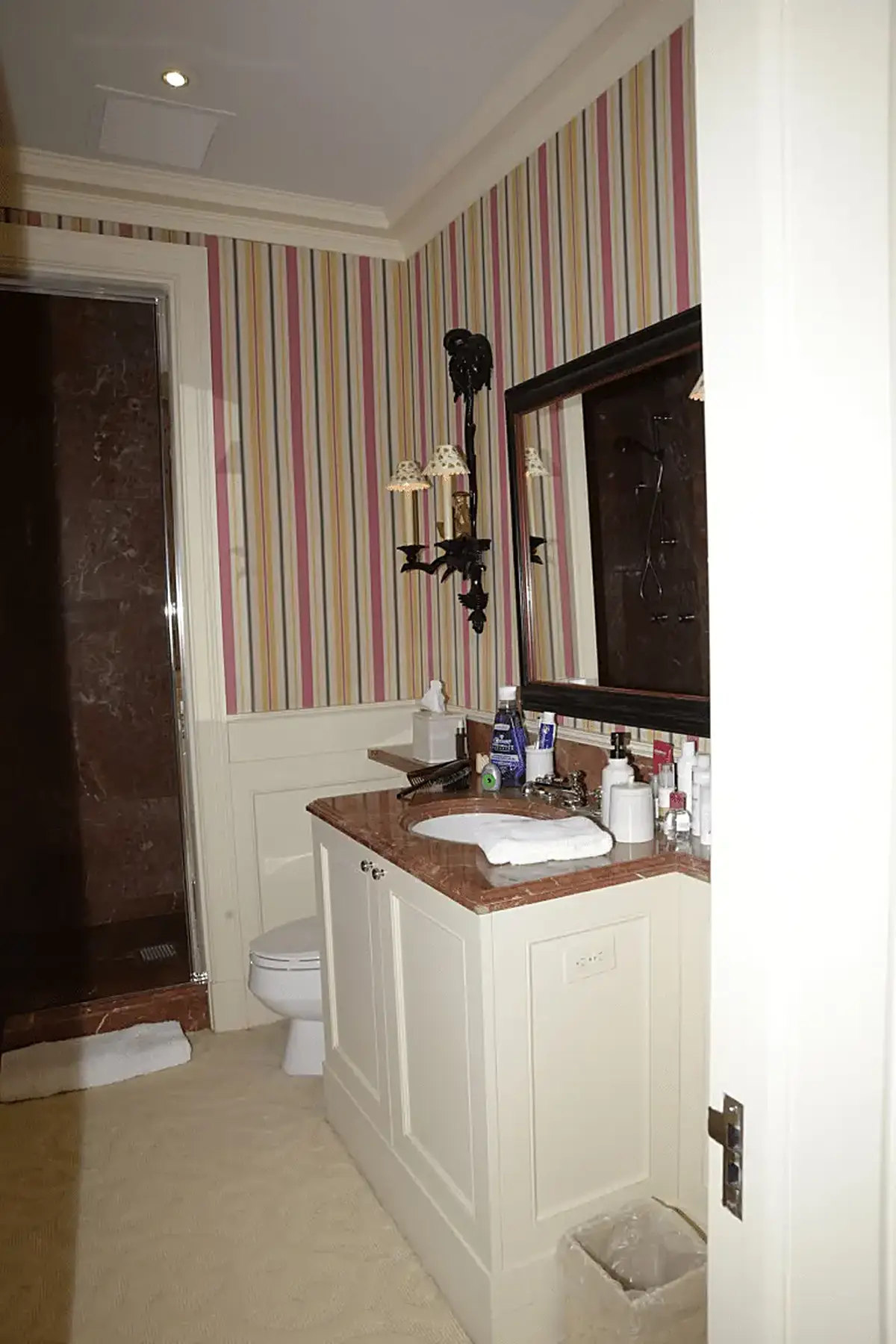 Bagno: EFTA00000227 - Bathroom with striped wallpaper a marble countertop and a large mirror