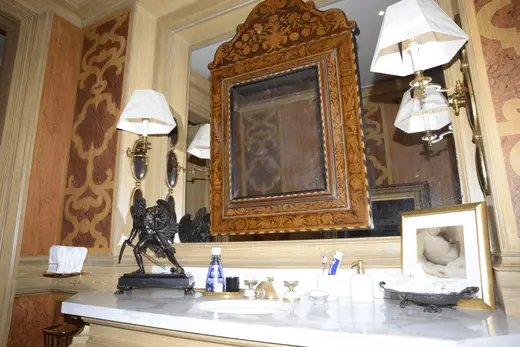 Bagno: EFTA00000140 - Elegant bathroom features ornate wooden mirror marble countertop vintage wa