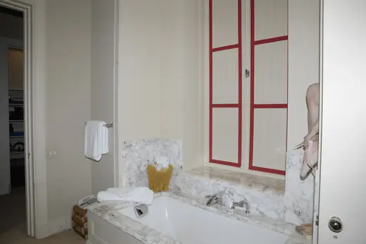 Bagno: EFTA00000614 - Bathroom with a white bathtub marble countertop red-framed window and a tow