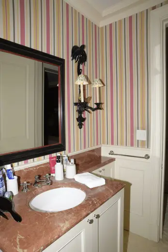 Bagno: EFTA00000230 - Bathroom with striped wallpaper a marble countertop and a black-framed mirr