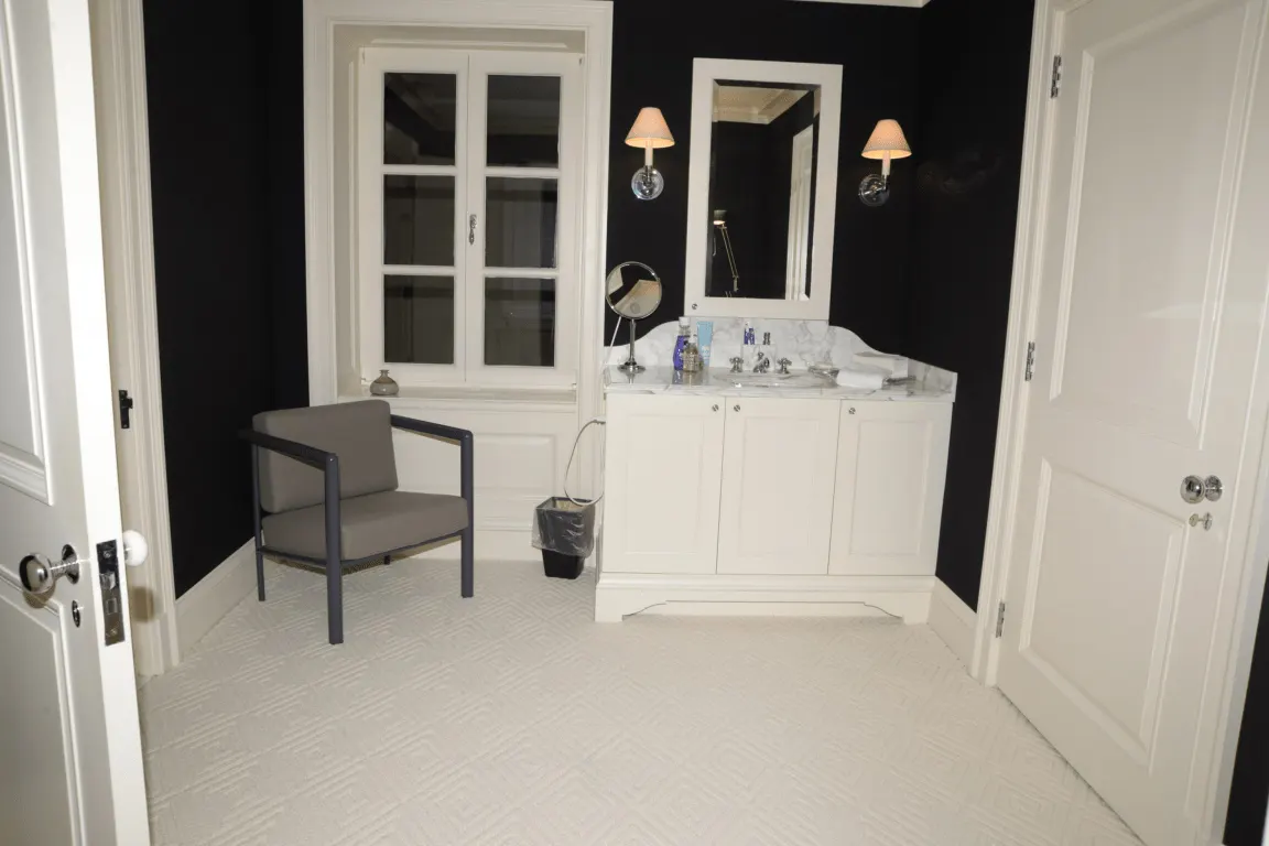 Bathroom: EFTA00000586 - Modern bathroom with black walls white cabinetry a marble countertop and a 
