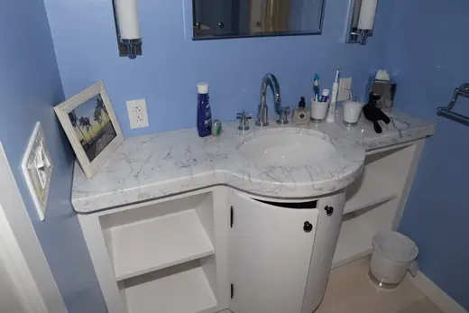 Bagno: EFTA00001791 - Bathroom with blue walls white vanity marble countertop and a sink featurin