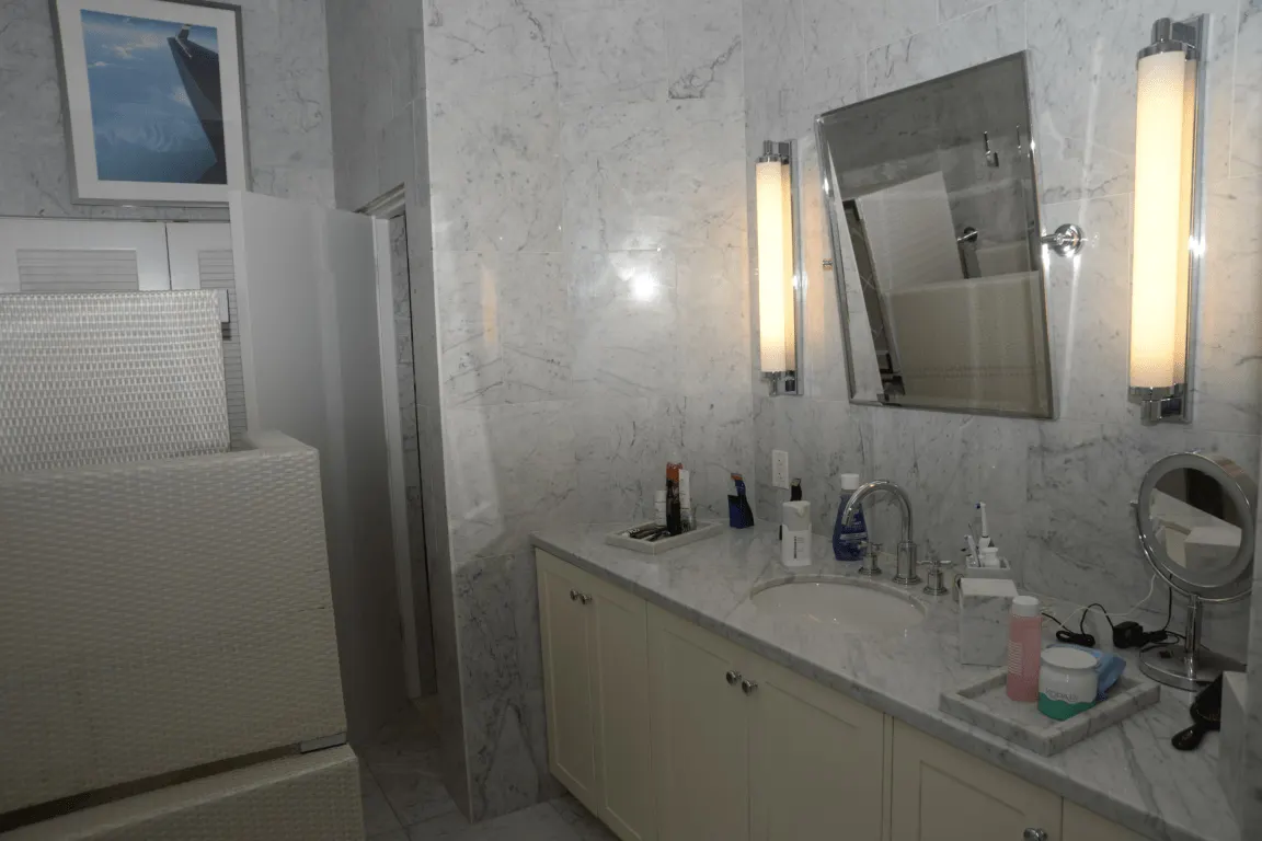 Bathroom: EFTA00002890-Pool-House - Elegant marble bathroom with white cabinetry sink and modern lig