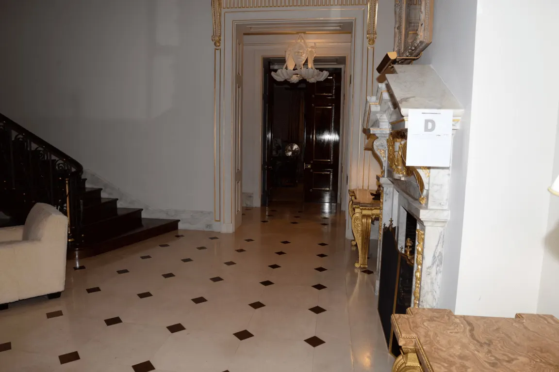 Flooring: EFTA00001493 - Grand hallway features a marble floor ornate fireplace and a staircase lead