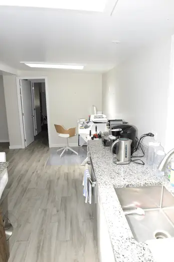 Kitchen: EFTA00002082 - Modern kitchen with light wood floors white walls and a granite countertop