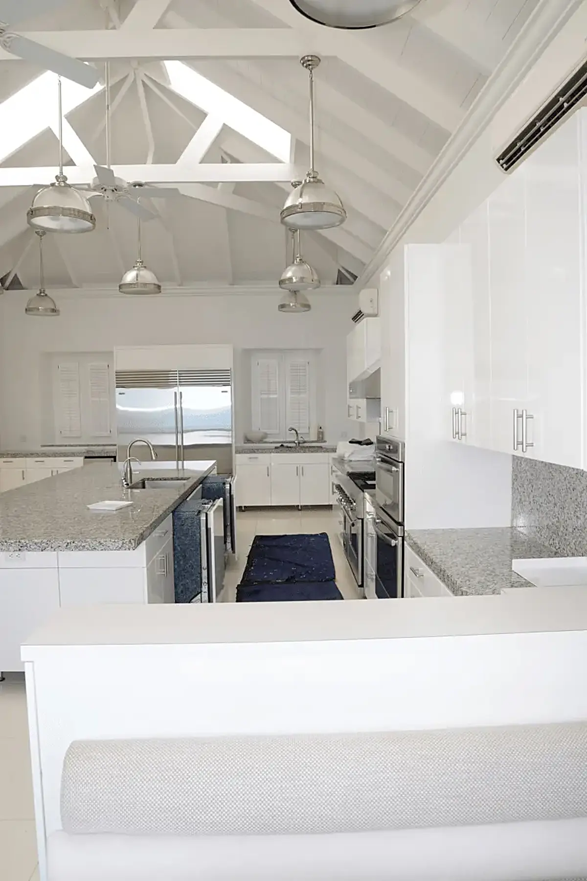 Cuisine: EFTA00001534 - Bright white kitchen with exposed beams pendant lights and granite countert