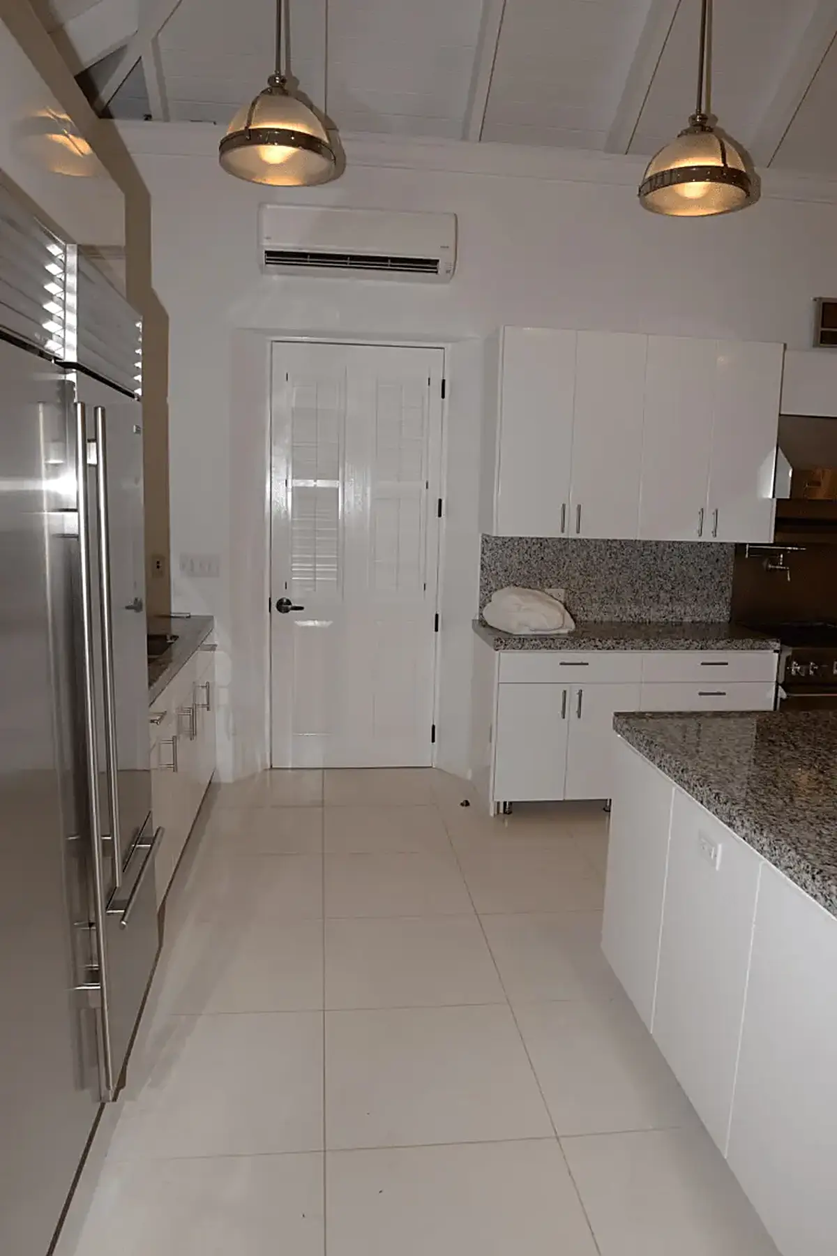 Kitchen: EFTA00002065 - White kitchen with granite countertops stainless steel appliances pendant l