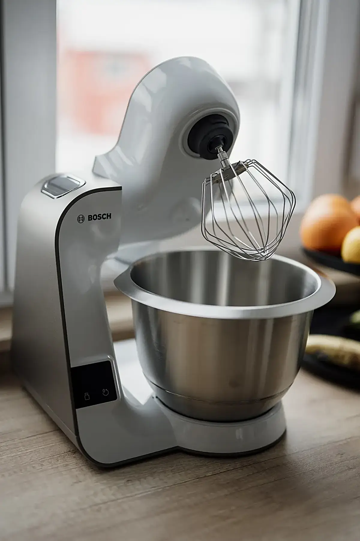 Cucina: Kitchen mixer sits on countertop near fruit bowl in bright kitchen
