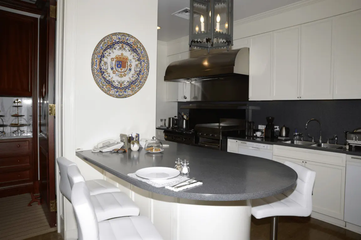 Кухня: EFTA00000072 - Modern kitchen with white cabinets a dark countertop and a decorative plate